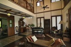 a large living room with wooden floors and ceiling fan in the middle of it's walls