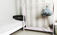 a white bed sitting next to a pink shelf