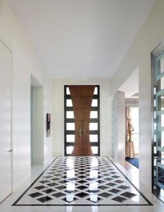 an entry way with black and white tiles on the floor