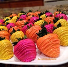 there are many different colored strawberries on the plate