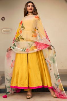 Featuring a yellow anarkali in cotton silk base with tassels and gota embroidery. It is paired with matching pants and an organza dupatta having floral print.  FIT: Fitted at bust and waist. COMPOSITION: Cotton silk, Organza. CARE: Dry clean only. Cotton Anarkali Suits, Yellow Anarkali, Full Sleeves Design, Haldi Outfits, Haldi Outfit, Silk Anarkali, Cotton Anarkali, Designer Anarkali, Floral Gown