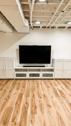 a large flat screen tv mounted to the side of a wall in an empty room