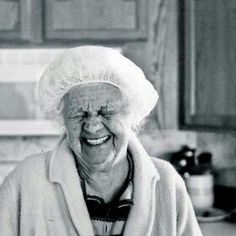 an old woman is smiling in the kitchen