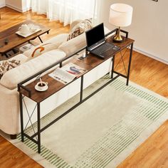 a living room filled with furniture and a laptop computer on top of a wooden table