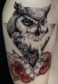 an owl tattoo on the thigh with roses and triangles around it's neck,