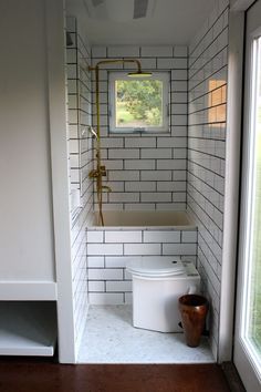 a white toilet sitting in a bathroom next to a window