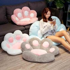 a woman sitting on a bean bag chair in front of several cat paws and paw cushions