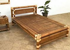 a bamboo bed frame with two nightstands and a potted plant