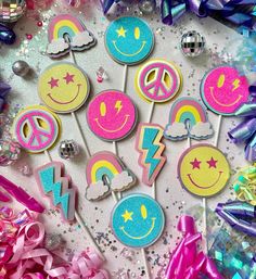 some lollipops that are decorated with smiley faces and rainbow colors on them