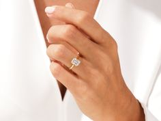 a woman's hand with a diamond ring on her left wrist, wearing a white shirt