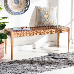 a wooden bench sitting on top of a white floor next to a potted plant