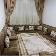 a living room filled with lots of brown furniture and pillows on top of a rug