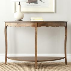 a table with a lamp on top of it next to a painting and a rug