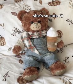 a teddy bear that is sitting on a bed with the caption she's so cute