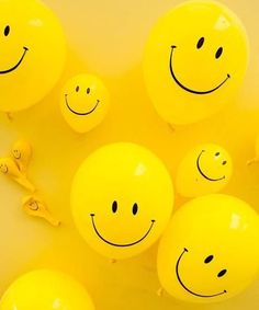 several yellow balloons with smiley faces on them