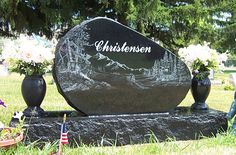 there is a memorial in the grass with flowers on it