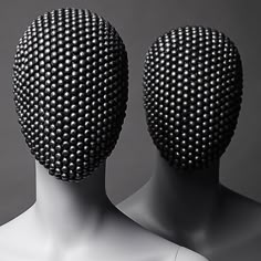 two white mannequins with black dots on their heads, facing each other