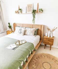 a bed sitting in a bedroom next to a window with plants on the headboard