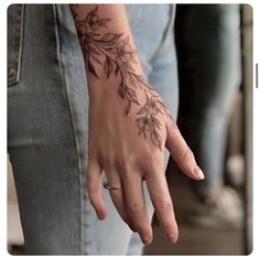 a woman's hand with a flower tattoo on it