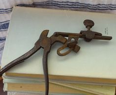 an old pair of scissors sitting on top of a pile of books next to each other