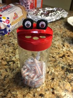 a plastic cup with eyes, nose and nails in it on a counter top next to other items