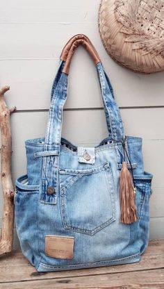 a blue jean purse sitting on top of a wooden bench