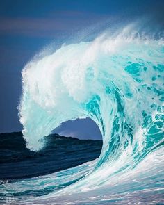 a large blue wave crashing into the ocean