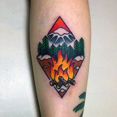 a colorful tattoo on the leg of a person with mountains and trees in the background