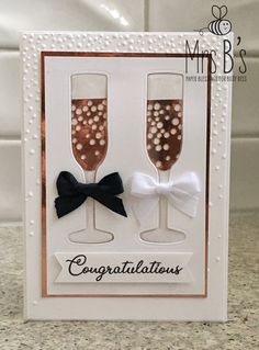 a card with two champagne glasses and a bow on the front that says congratulations