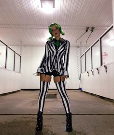 a woman dressed as beetlegirl standing in an empty room