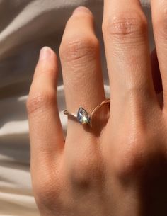 a woman's hand with a diamond ring on top of her left hand,