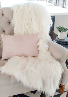 a white chair with some pillows on it