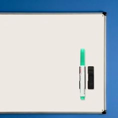 a white board with a green marker on it and a black pen next to it