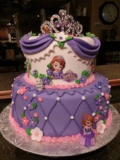 a purple and white cake with princesses on it