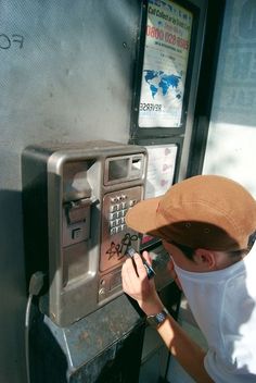 a man in a hat is using an atm machine