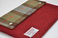 a close up of a red cloth with a tag on the side and a plaid pattern