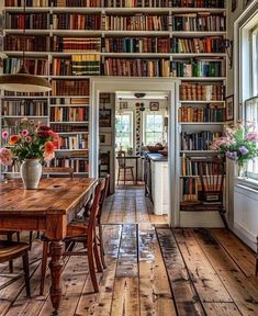 a room filled with lots of books on top of a book shelf next to a window