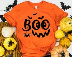 an orange t - shirt with the word boow on it and bats around it