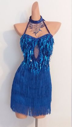 a mannequin wearing a blue dress with fringes and beads on the neck