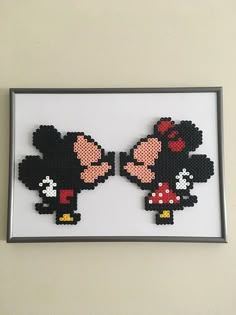 two pixelated mickey and minnie mouses are in a frame on the wall next to each other