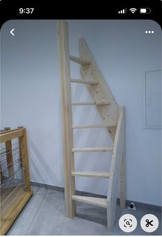 a wooden stair case next to a handrail in a room with white walls and flooring