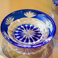 a blue glass bowl sitting on top of a table