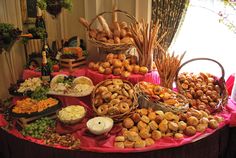 a table filled with lots of different types of breads and pastries on it