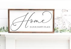 a sign that says home is our happy place on the mantle next to a potted plant