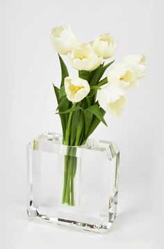 white tulips are in a clear glass vase