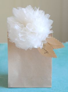 a small white flower in a brown paper bag