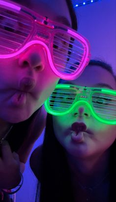 two children wearing neon glasses in the dark