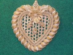 a gold heart shaped brooch sitting on top of a green surface