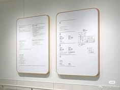 two large white boards mounted to the wall in an office building with metal railings