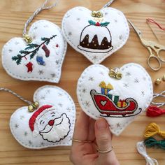 someone is holding three ornaments in the shape of hearts